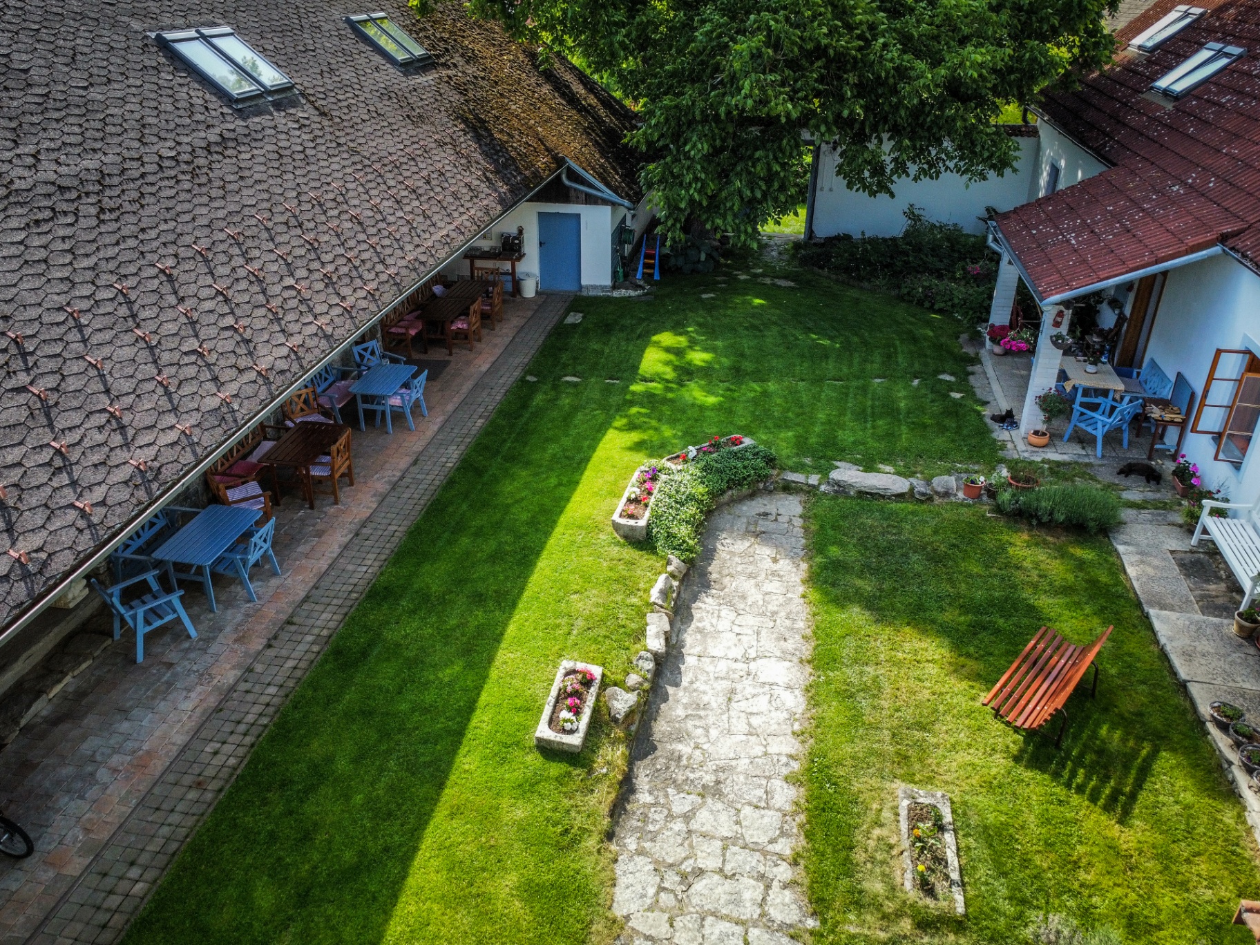 Zahrada Malíkovského Dvora s jabloněmi a houpací sítí